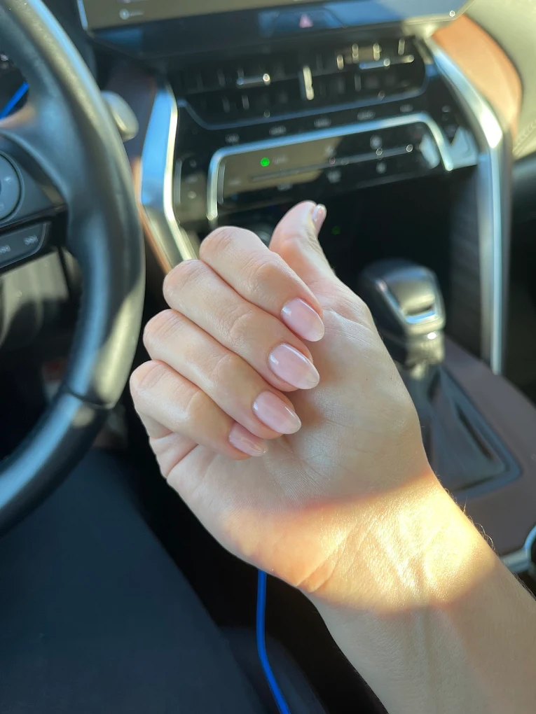 Natural nude almond-shape nails in warm sunlight
