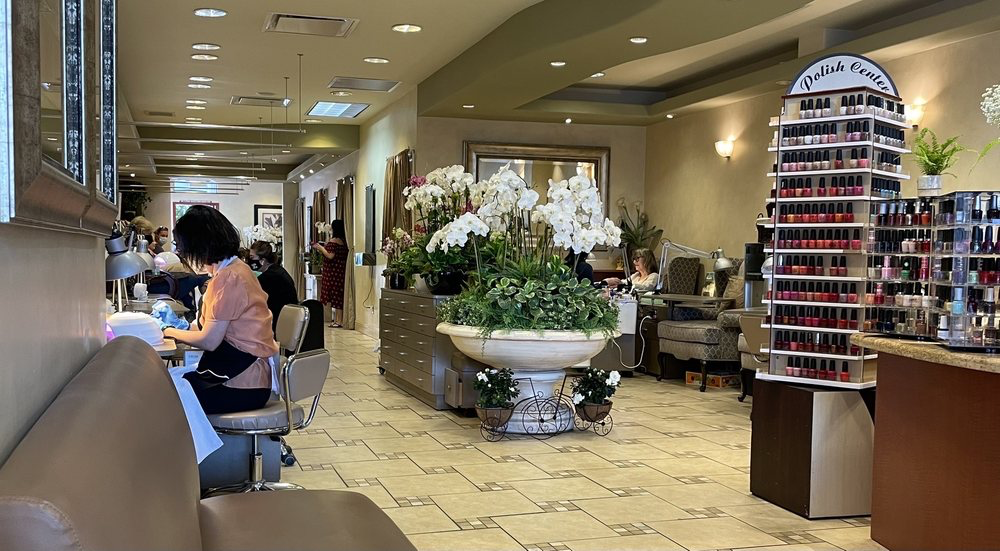 Interior of A Touch of Elegance nail salon with white orchids and warm lighting
